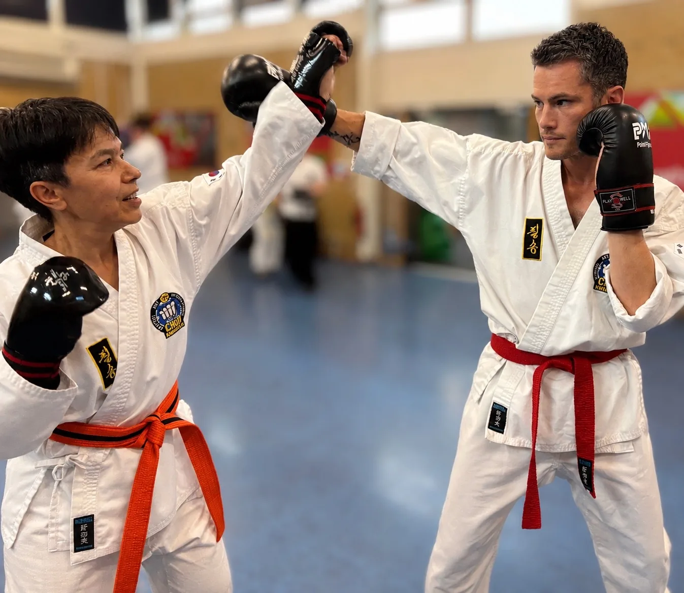 Adult students practising pad work in a Teddington Choi Kwang Do class